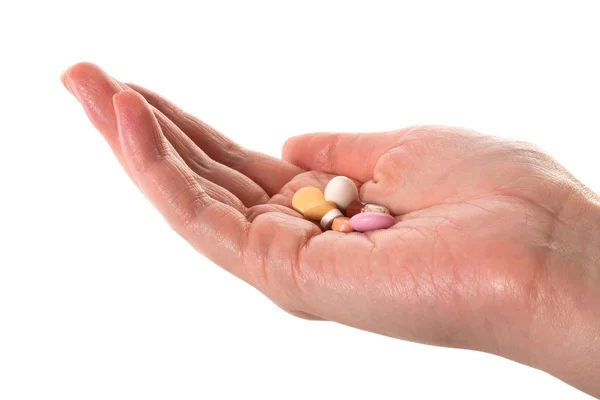Mão segurando pílulas coloridas — Fotografia de Stock