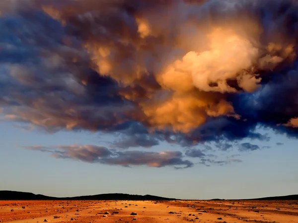 Dunkle Wolken über der steinigen Wüste. — Stockfoto