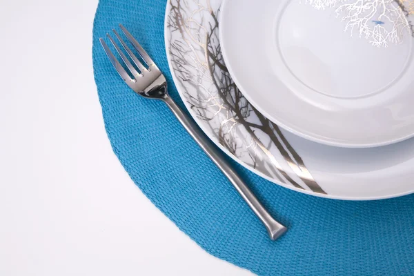 Platos y tenedor servidos en un mantel — Foto de Stock