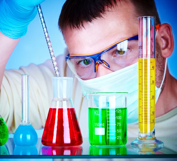 Científico en laboratorio con tubos de ensayo — Foto de Stock