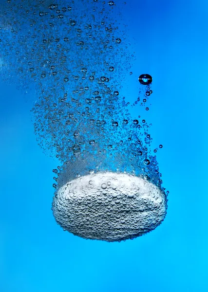 Яркая таблетка в воде с пузырьком — стоковое фото