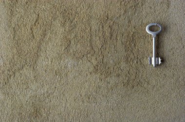 Iron key on a concrete wall clipart