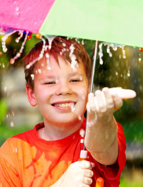 Хлопчик під парасолькою під час дощу — стокове фото