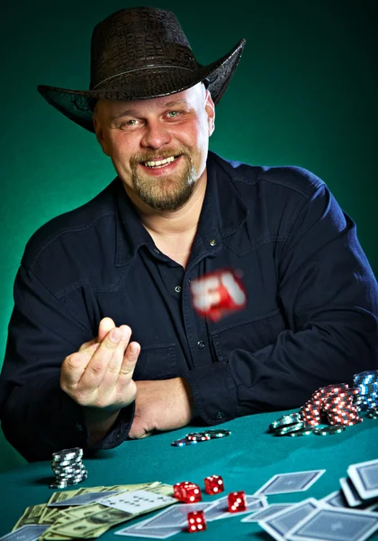Man throws dice on a green background — Zdjęcie stockowe