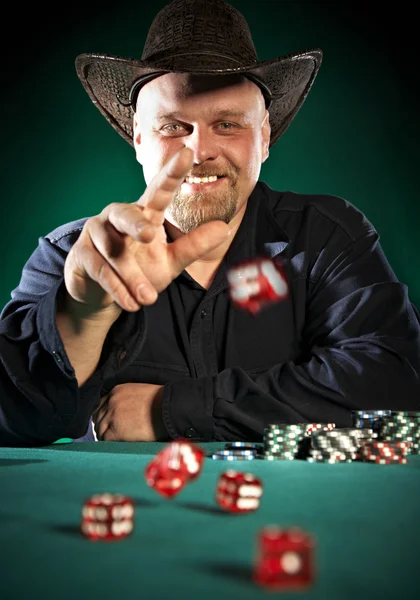 Man throws dice on a green background — Zdjęcie stockowe