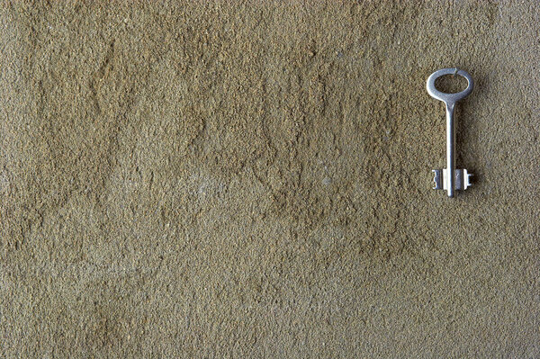 Iron key on a concrete wall
