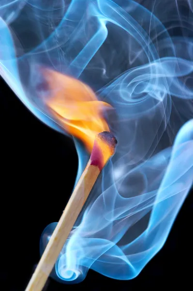 Photo d'un match brûlant dans une fumée sur un — Photo
