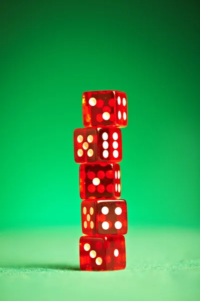 Červené kostky na zelenou látkou — Stock fotografie