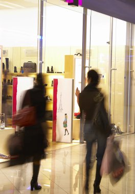 Two girls in shopping center near a show clipart