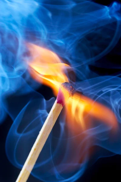 Foto di un fiammifero che brucia in un fumo su un — Foto Stock