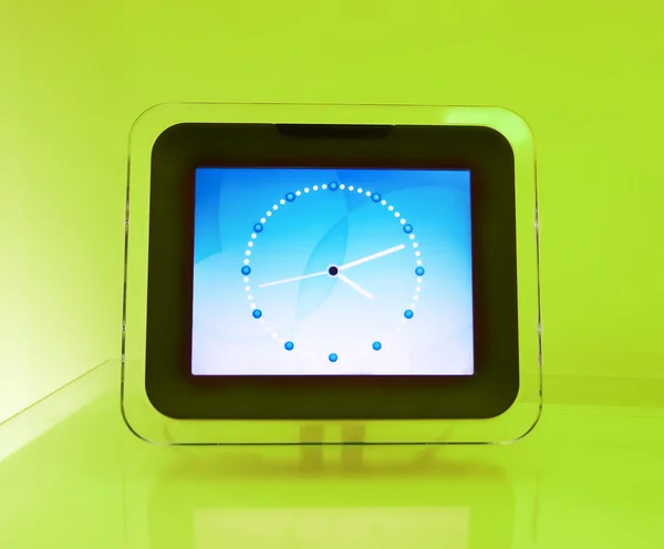 Kék elektronikus óra, egy zöld háttérben — Stock Fotó