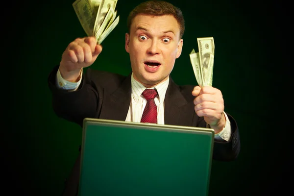 Man with money in hands at the monitor — Stock Photo, Image