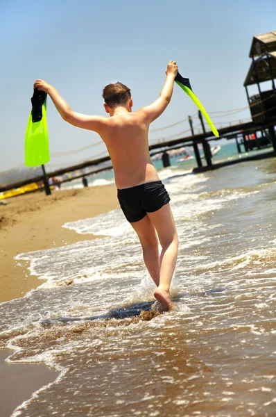 Pojken går längs havskusten — Stockfoto