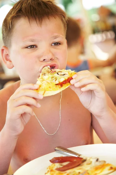 Junge isst eine Pizza — Stockfoto