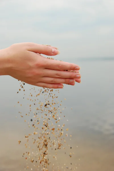 Sand i kvinnliga händer — Stockfoto