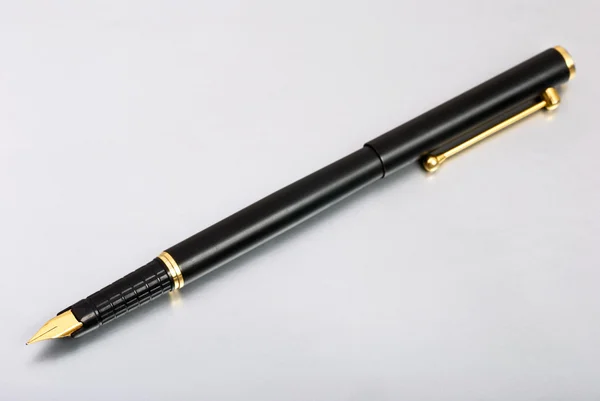 Золота чорнильна ручка на сірому фоні — стокове фото