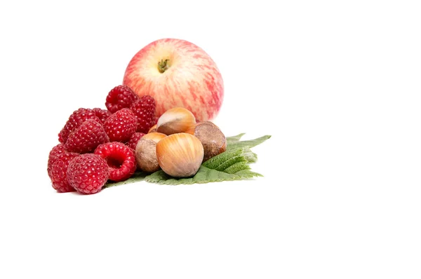 Hazelnuts,apple and raspberries on a whi — Stock Photo, Image