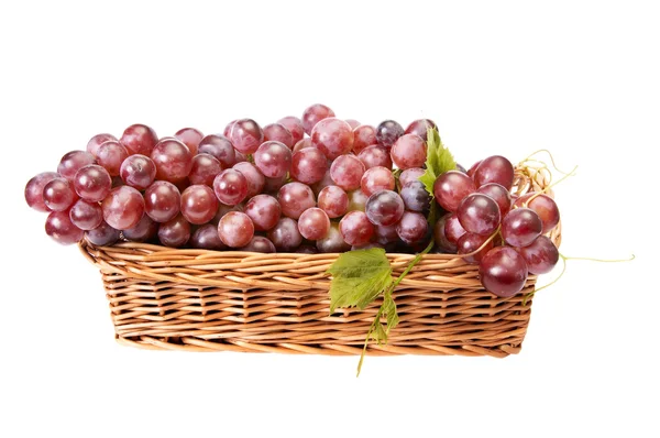 Houten mandje en rijpe druiven op een wit — Stockfoto