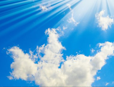 Splendid sunbeams and clouds on blue sky clipart