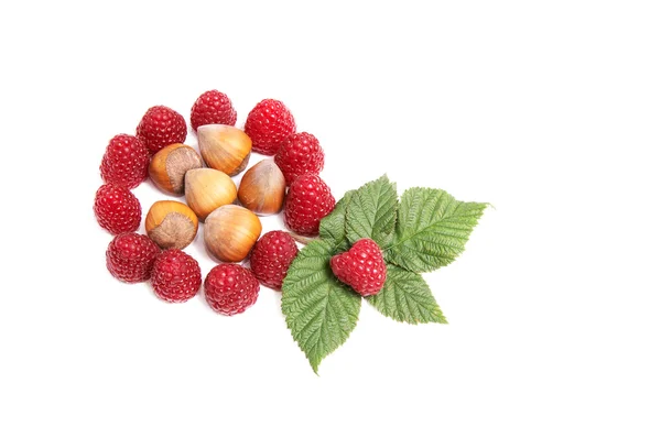 Tasty,juicy raspberries and nuts on a w — Stock Photo, Image