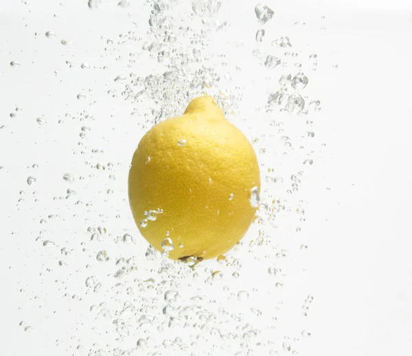 Alone lemon is dropped into fresh water. — Stock Photo, Image