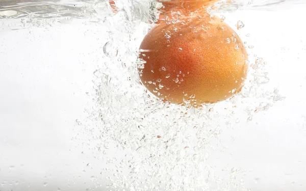 Grapefruit is falling into water. — Stock Photo, Image