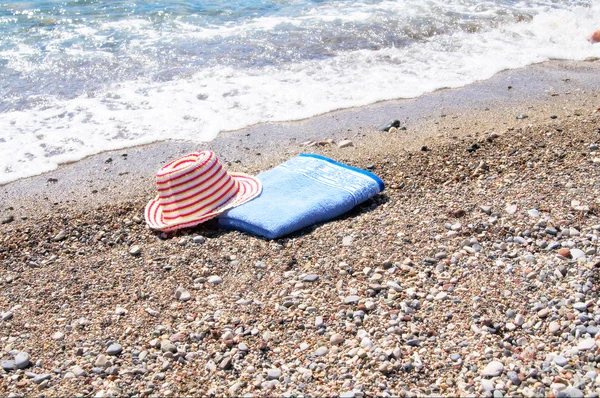 Turquoise zee, zon hoed en handdoek. — Stockfoto