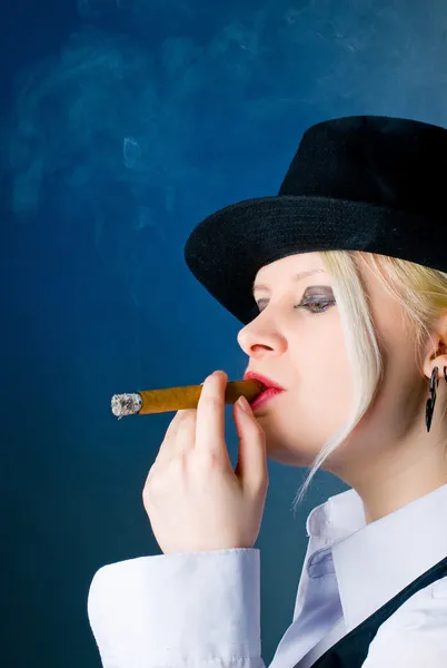 Şapkalı bir kadın bir puro sigara içiyor. — Stok fotoğraf