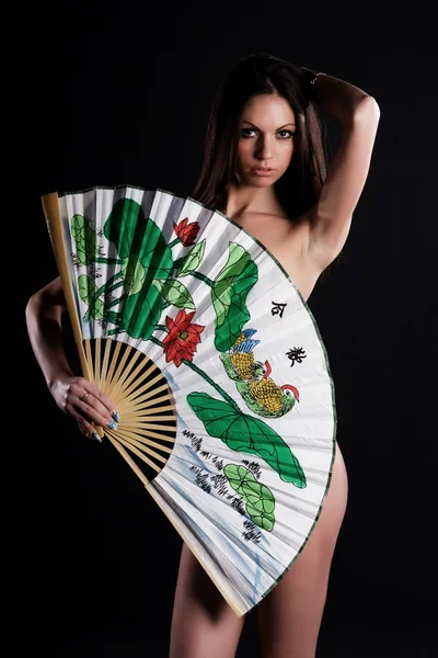 Mujer joven atractiva con ventilador brillante — Foto de Stock