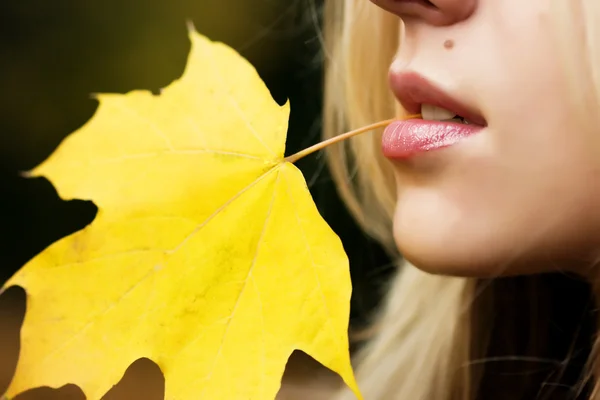 Akçaağaç yaprağı ağzında olan kız — Stok fotoğraf