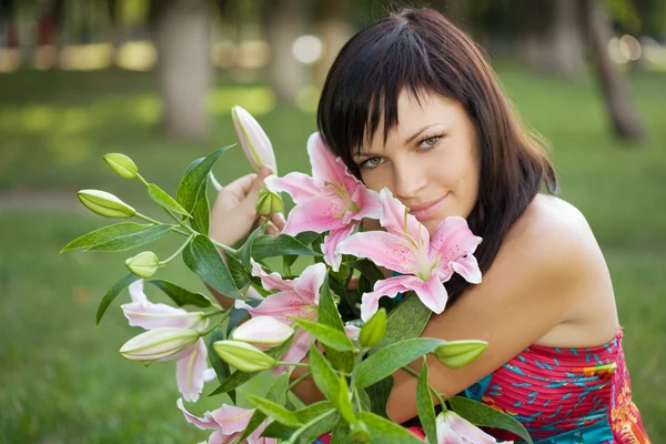 Vacker ung kvinna med liljor — Stockfoto