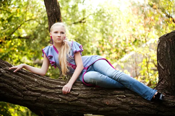 Genç ve güzel kız bir ağaç üzerinde — Stok fotoğraf