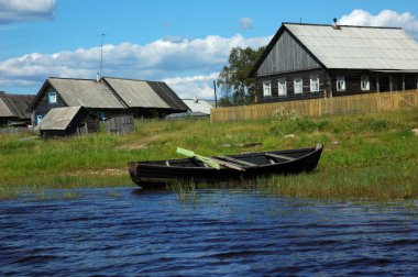 Wooden boat on the lake bank clipart