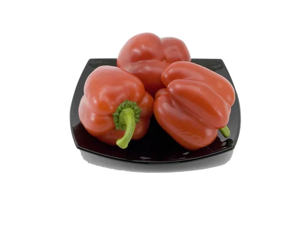 Červené papriky na černé nádobí — Stock fotografie