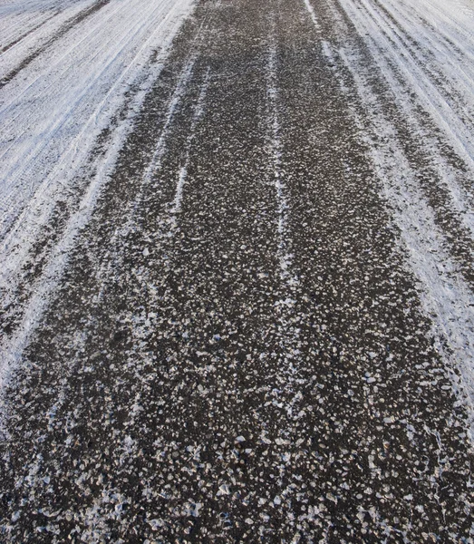 Асфальтовое дорожное покрытие зимой — стоковое фото