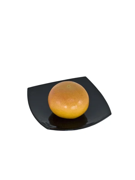 Грейпфрут в чорній тарілці — стокове фото