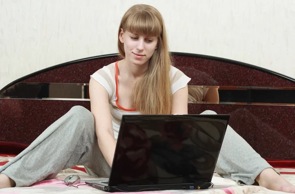 Weibchen surft auf ihrem Bett im Internet — Stockfoto