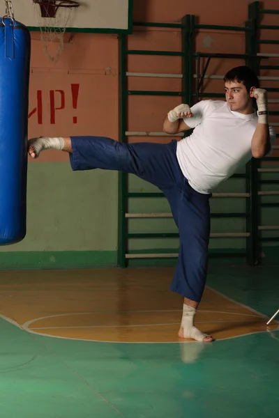 Kickboxer treten gegen den Sandsack — Stockfoto