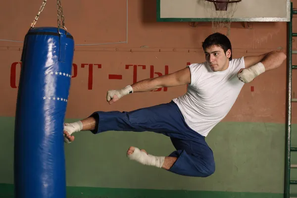 Kick-boxer, kopiąc sandbag — Zdjęcie stockowe