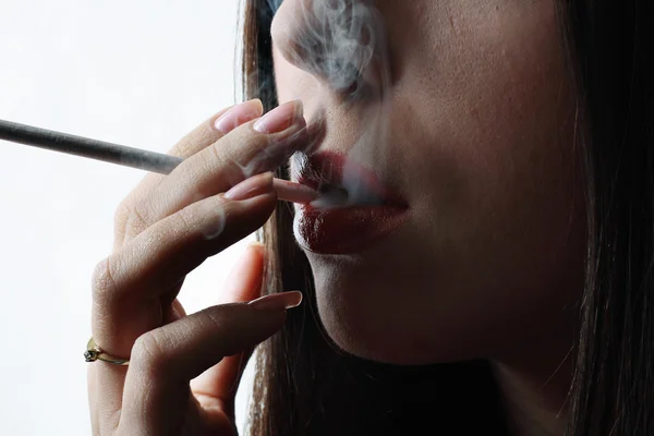 Молодая женщина, курящая сигарету. — стоковое фото