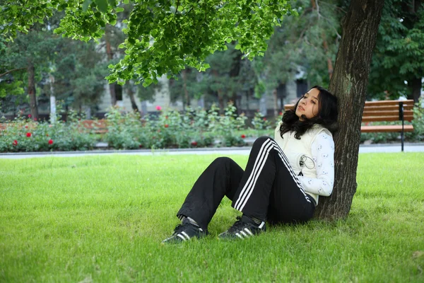 Beautiful girl sitting down of grass — Stock Photo, Image