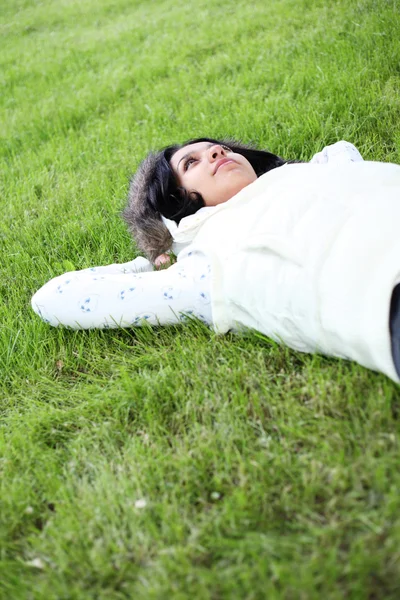 Vacker flicka som ligger ner av gräs — Stockfoto