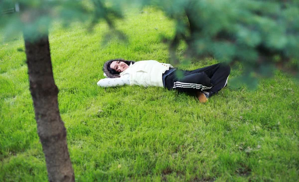 Beautiful girl lying down of grass — Stock Photo, Image