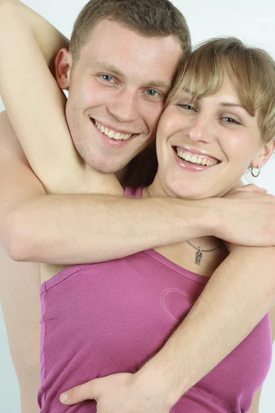 Молодая влюбленная пара улыбается. По белому бу — стоковое фото