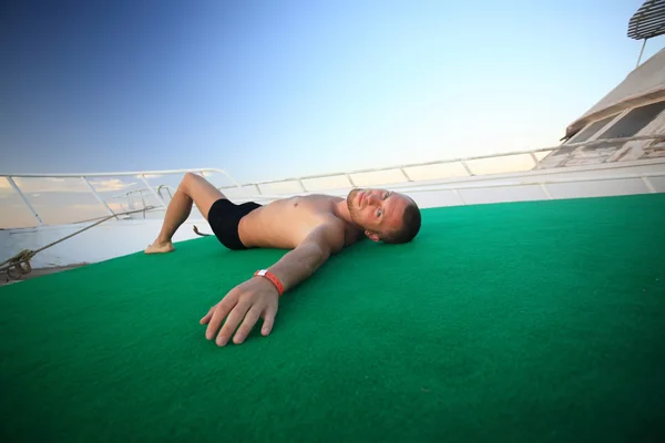 Muž leží na lodi — Stock fotografie