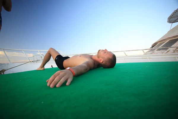 Homem deitado no barco — Fotografia de Stock