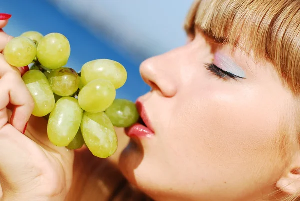 Portrait of a beautiful girl with grapes on teh beach — Stock Photo, Image