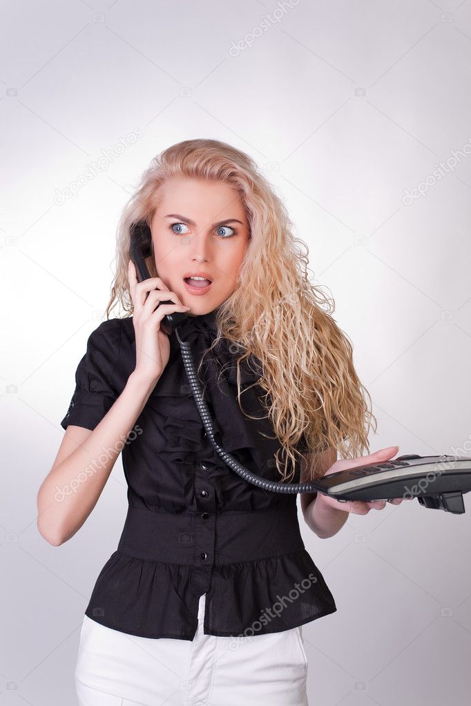 Shocked businesswoman with a phone