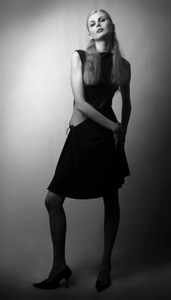 Langhaarige junge Mädchen im schwarzen Kleid — Stockfoto