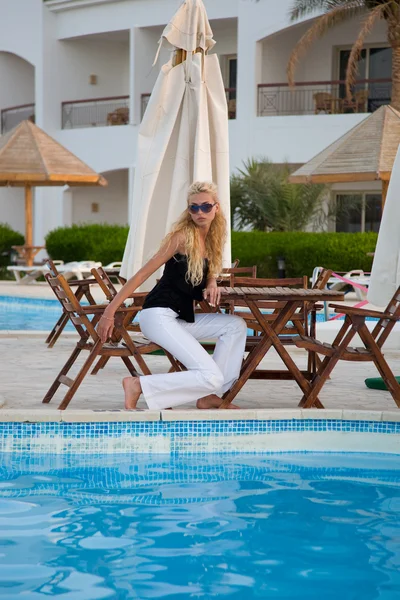 Kaukasiska ung modell sitter av en pool — Stockfoto